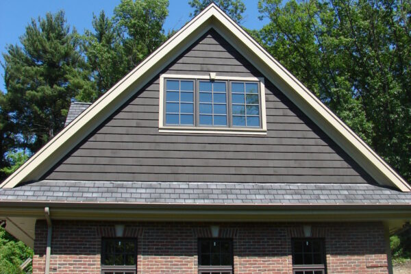 Burnt Hickory solid color prefinished cedar shingle siding on a front gable above a brick first floor, with light trim and a multi-pane window.