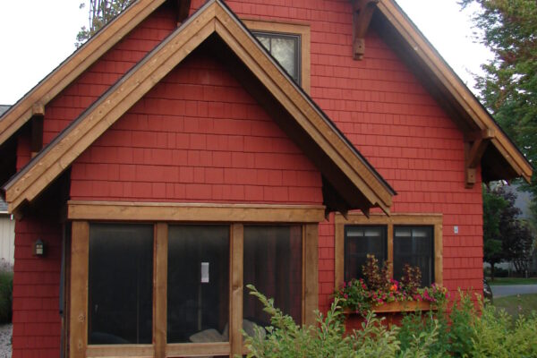 Flint Corn solid color prefinished cedar shingle siding on a cottage-style home with natural wood trim and multiple gables.