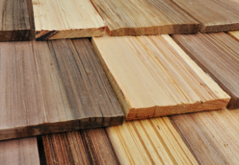 Close-up of cedar shakes installed in staggered rows, showing natural color variation from light tan to weathered brown.